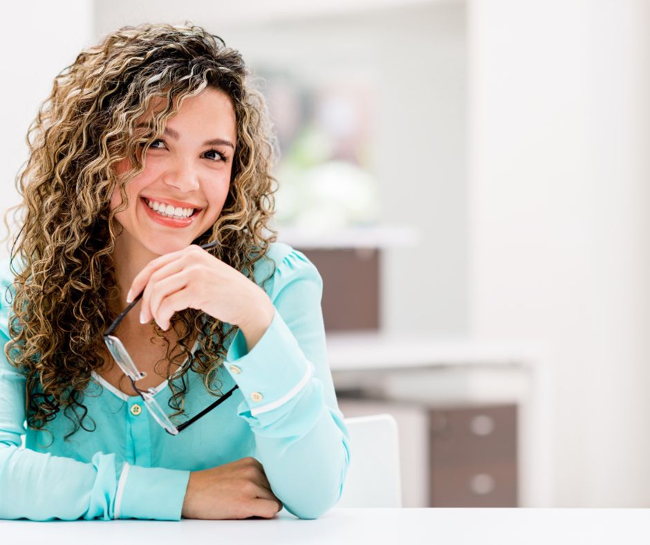 A woman in aqua shirt smiling and full of confidence and power.