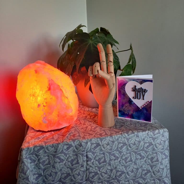 a rock salt lamp and a hand gesture on a table