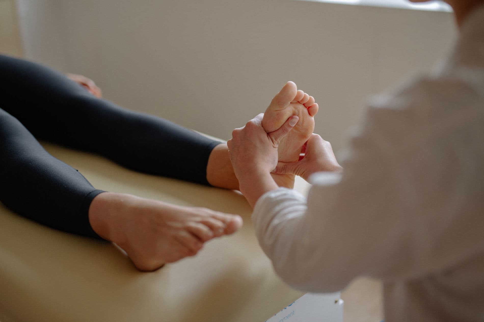 Image of reflexology treatment Shows client legs resting on treatment table with bare feet being given a reflexology treatment at Energy Flows in Maynooth Co. Kildare